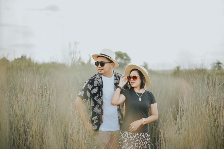 two people standing next to each other in a field