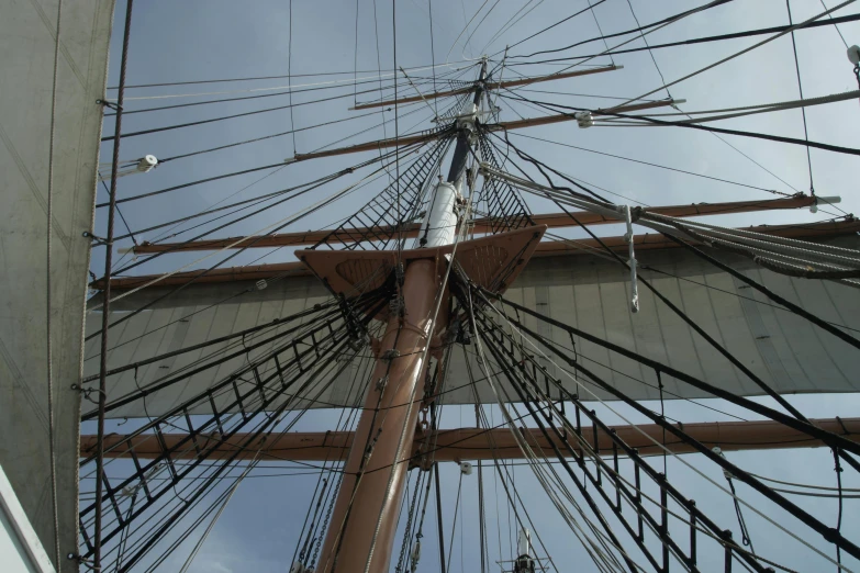 looking up at the bow of a sailboat with many strings