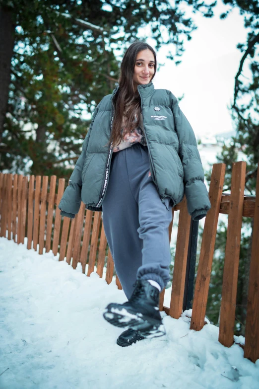 the woman in snow suit is standing on her snowboard