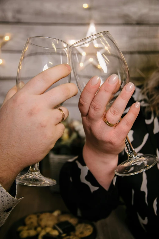 a person holding a glass of wine and toasting it