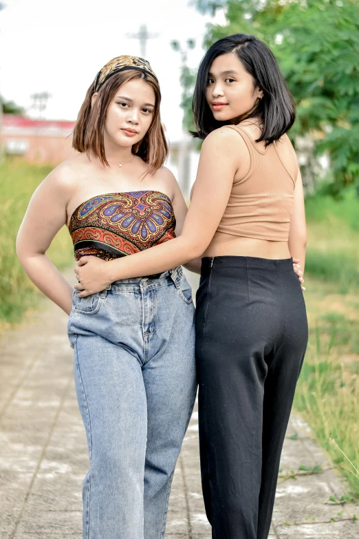 two women standing next to each other on a sidewalk