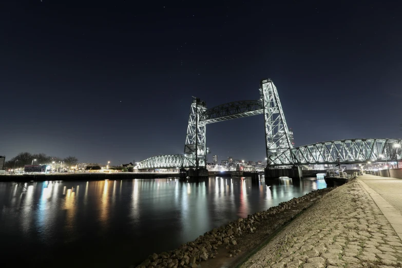 a very tall bridge across a river in a city