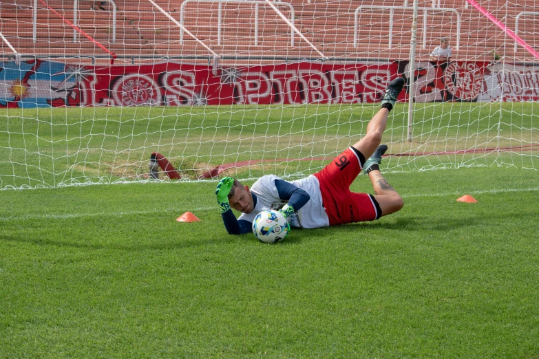 the soccer player is falling on his knees as he attempts to take possession of the ball