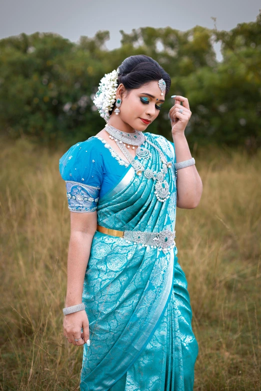 the woman is dressed in a sari, posing for a po