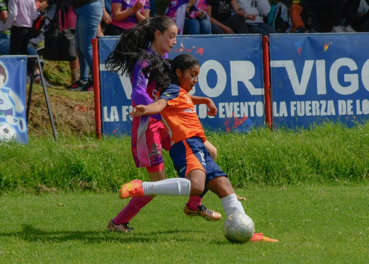a couple of girls playing a game of soccer