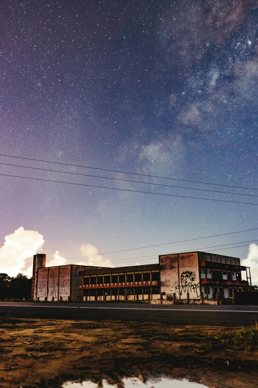 a very old building on the corner of a road with stars in the sky