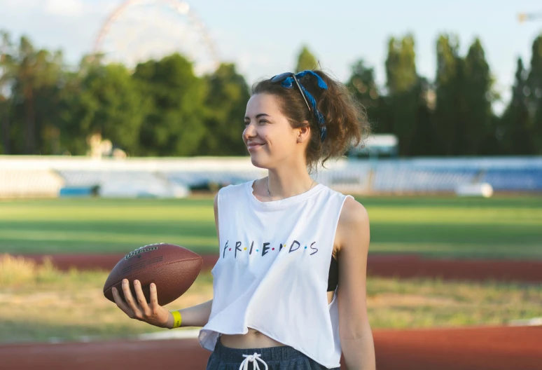 a woman standing next to a football