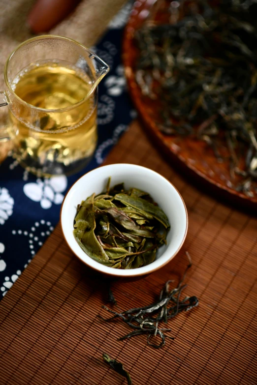 the tea leaves in the bowl have been placed beside them