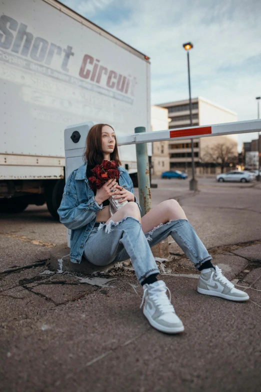 a woman is sitting on the side of the street