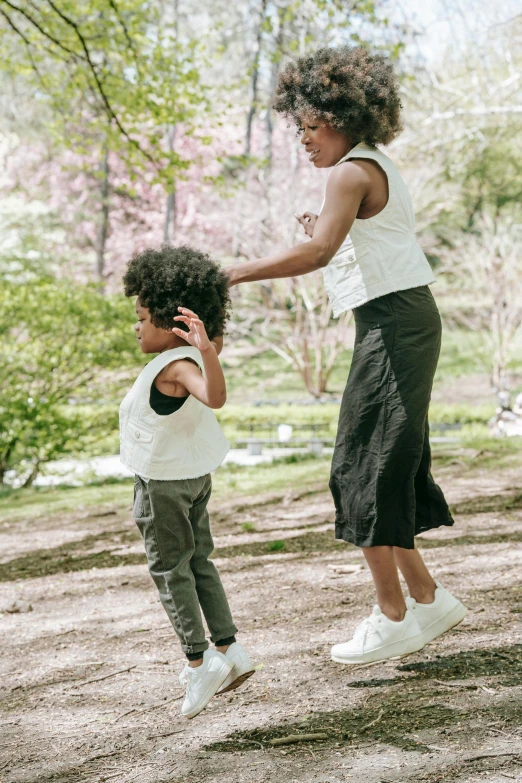 a woman plays with a little boy's hand