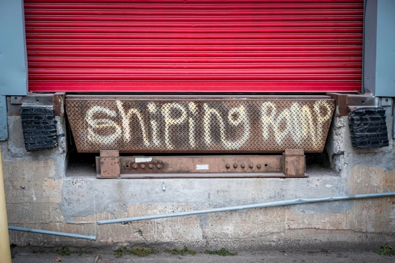 an old dirty sign that is sitting next to a red door