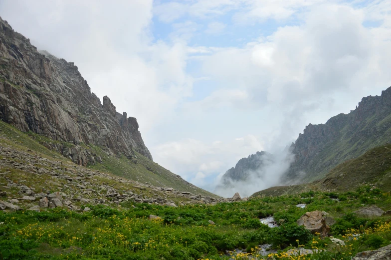 some very pretty mountains with some clouds coming out of them