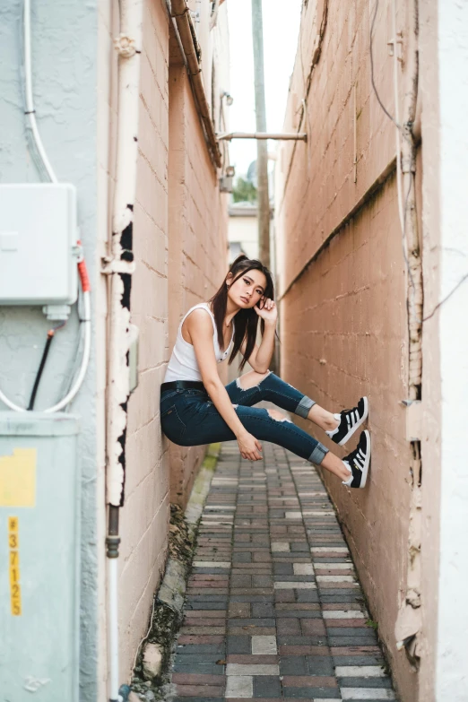 a woman is sitting on a wall looking away