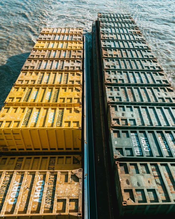 four train cars with large yellow sections and water