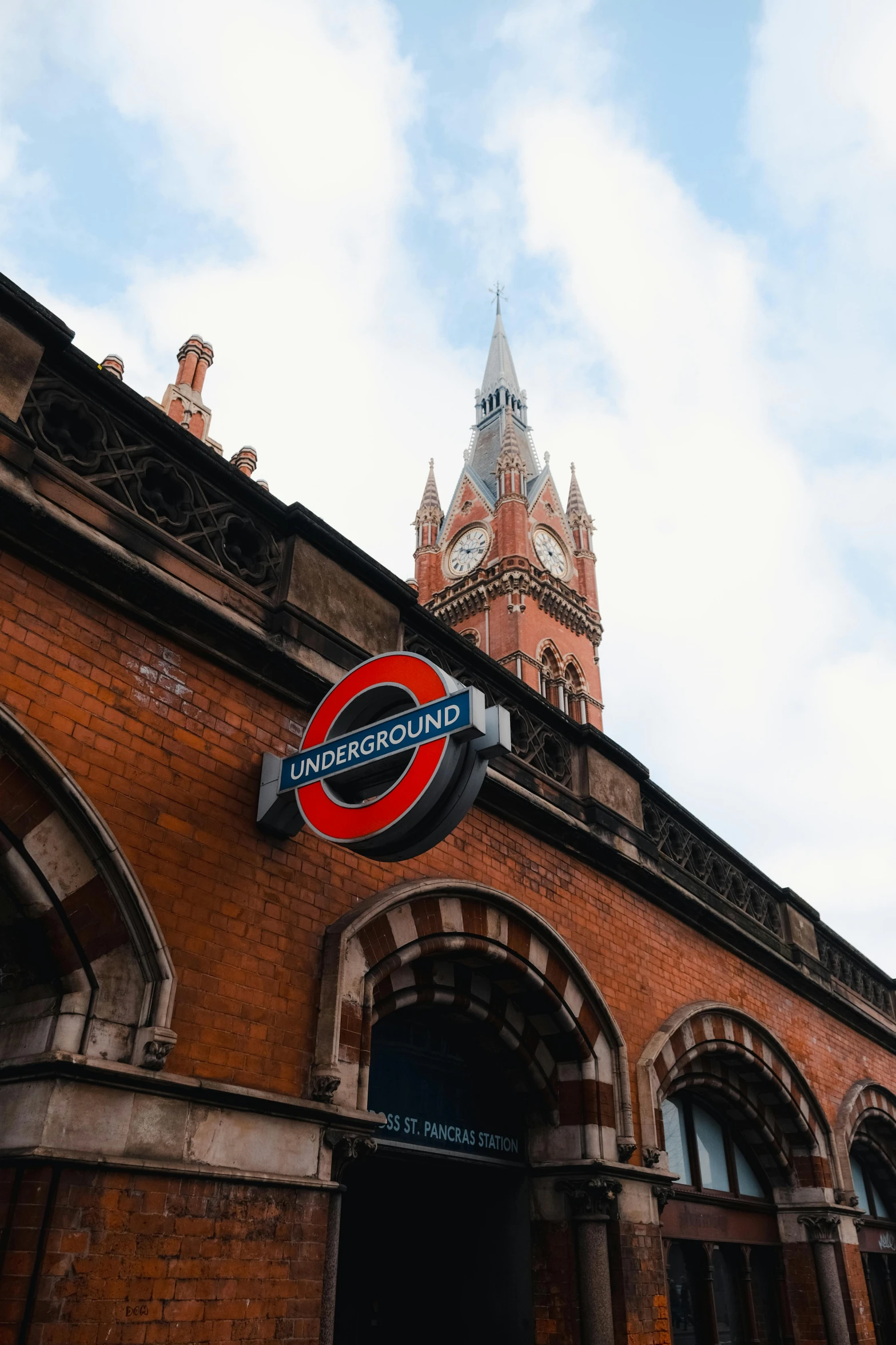 a red train sign and a brown brick building