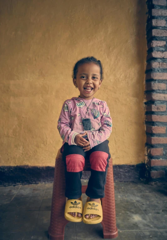 a  sitting on a chair in yellow rubber shoes