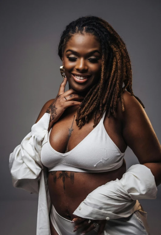 a beautiful woman with dreadlocks and tattoos smiling