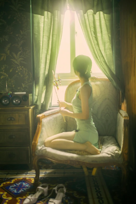 a woman sitting in front of a window in a white shirt