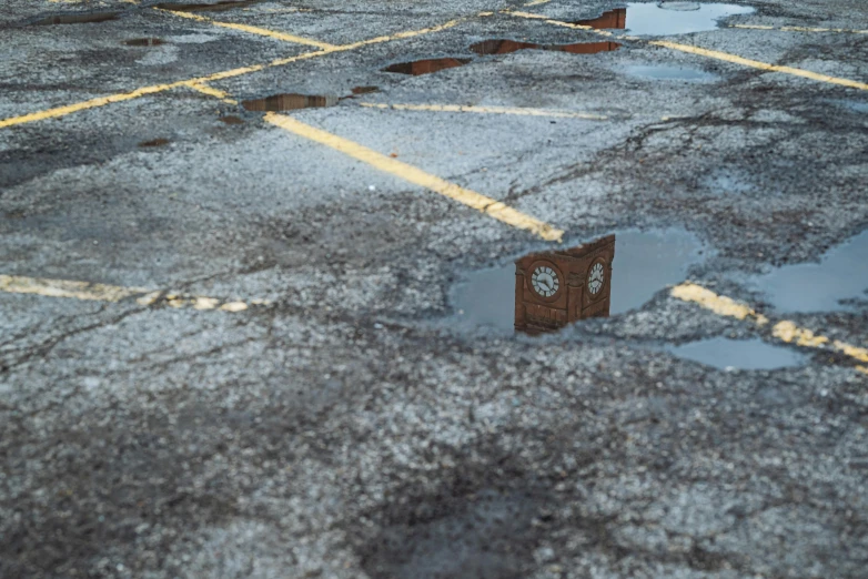 a broken clock sitting on the ground next to a building