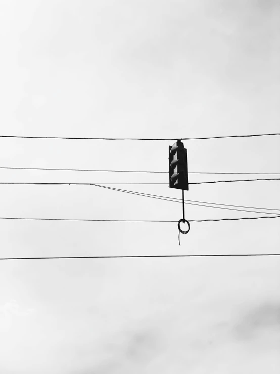 a traffic light suspended from a wire under a cloudy sky