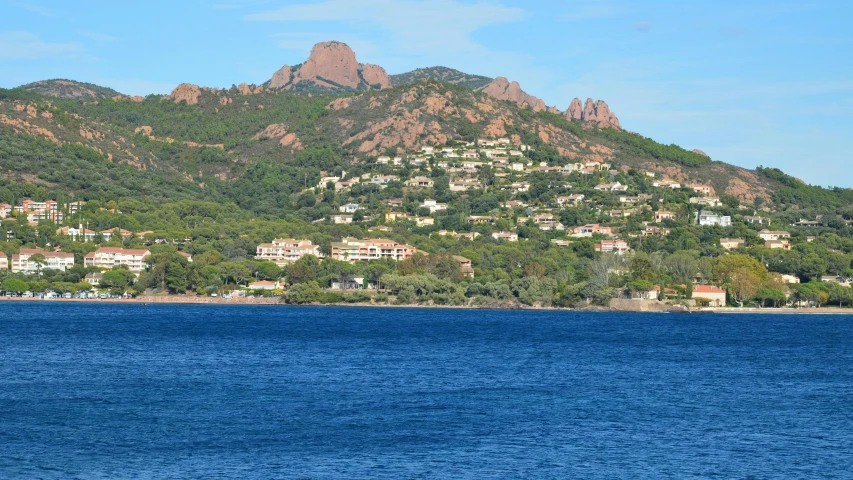 a lake in front of a mountain with houses on the mountains