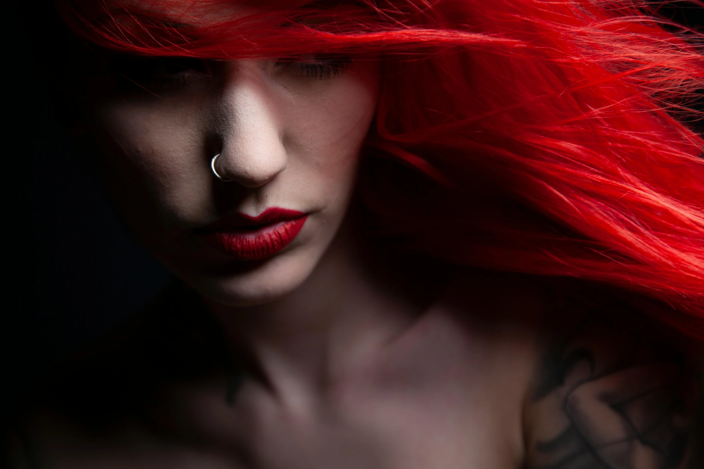 the woman has red hair with piercings on her ears