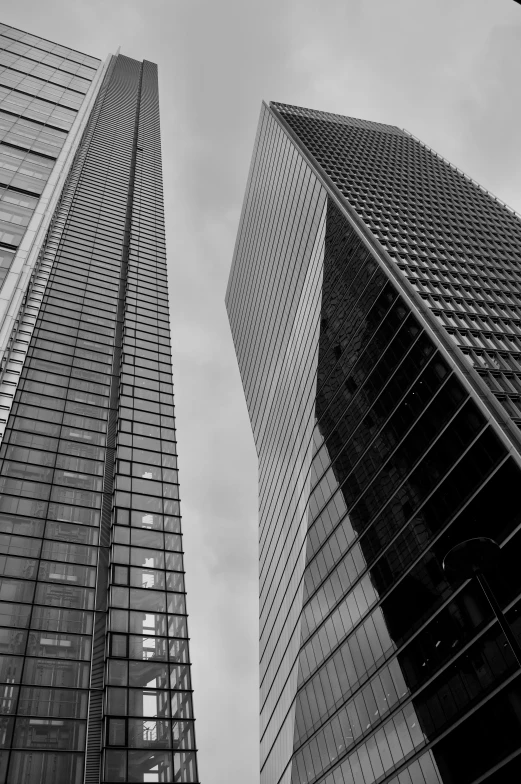 black and white pograph of two tall glass buildings