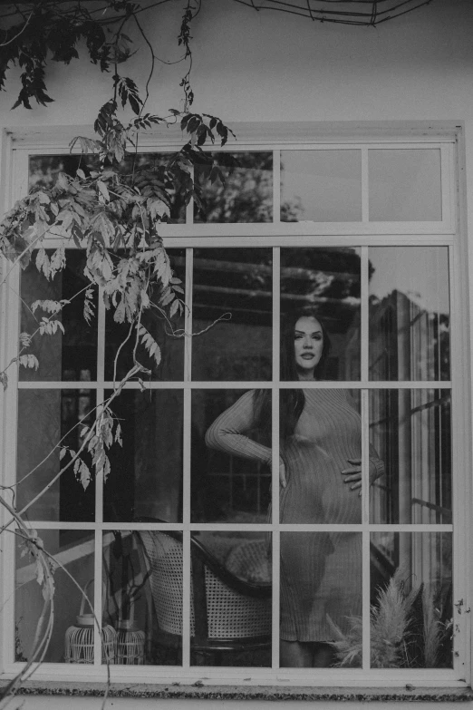 a woman standing outside of a window looking in