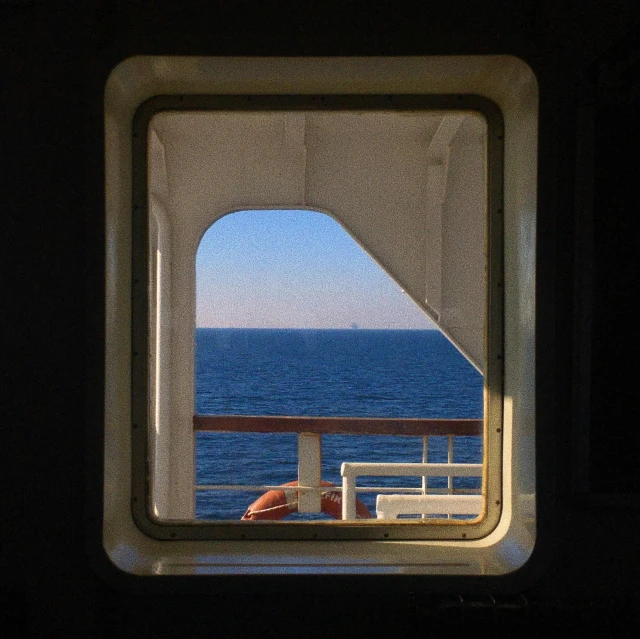 a window looking at a ship out to the water