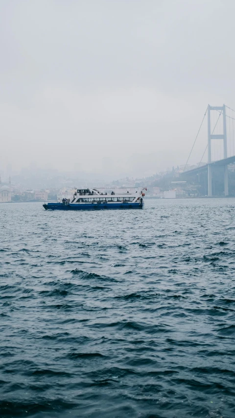 a ferry traveling through the water on a foggy day