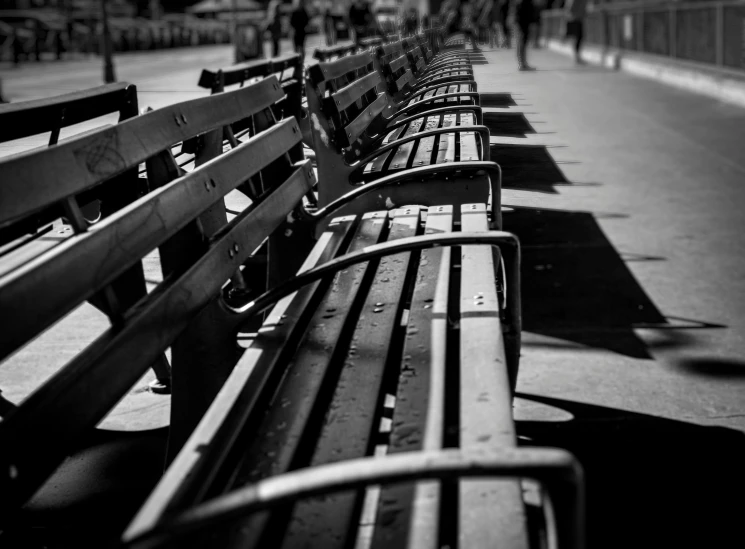 a row of park benches on a sidewalk