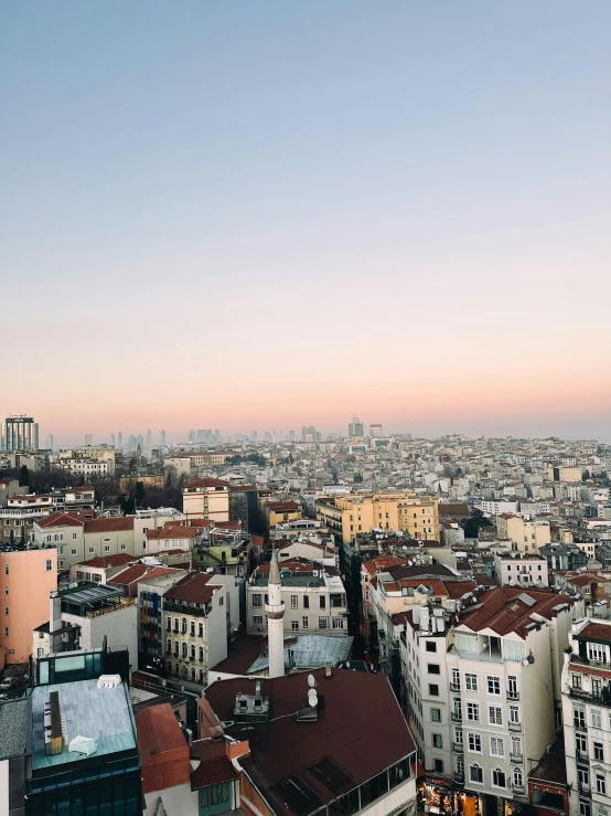 rooftops, buildings and the ocean are seen at sunset