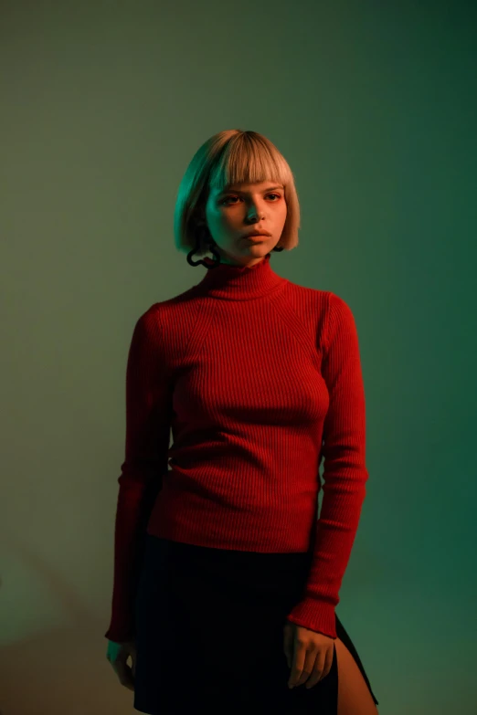 a woman in a red top and skirt standing by a wall