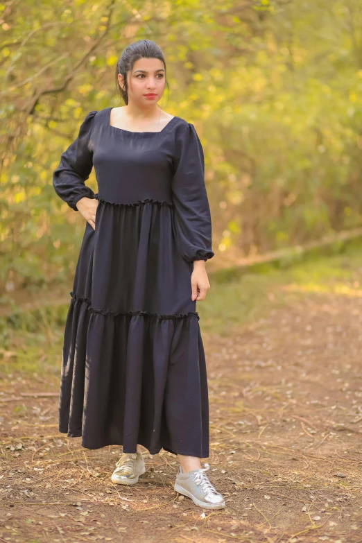 a woman wearing a long dress posing for a po