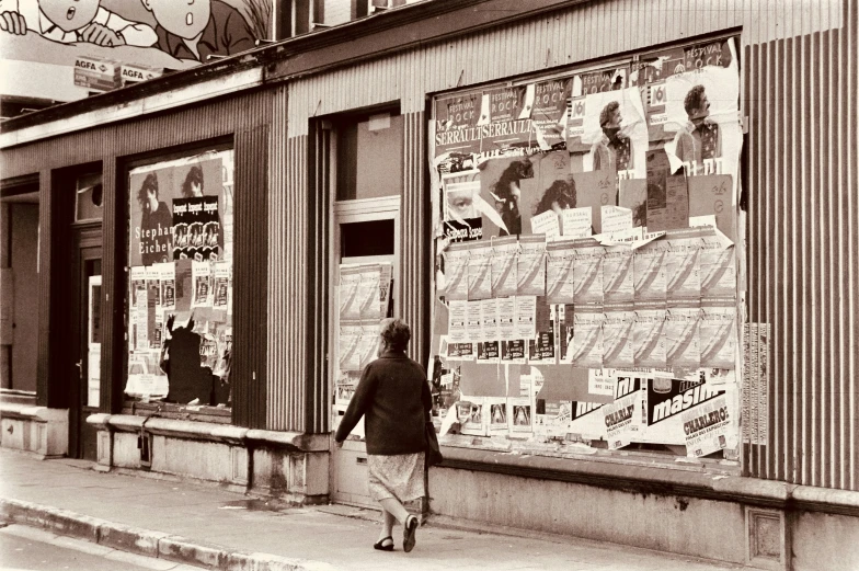 black and white po of person walking past storefront