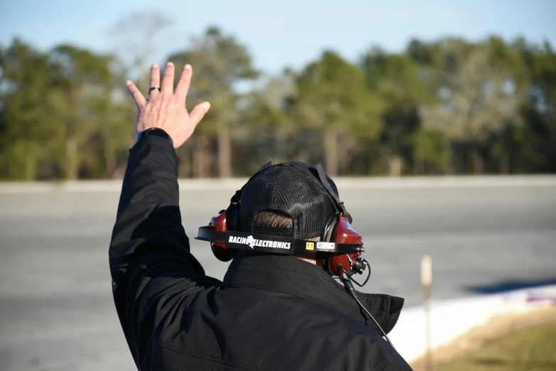 the person in the helmet is waving to soing