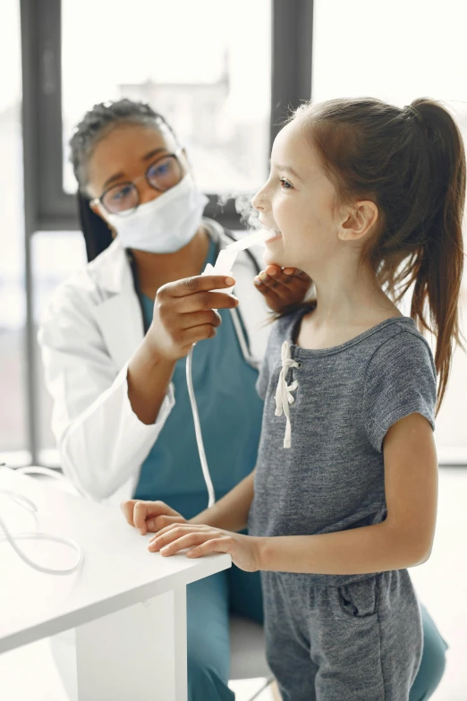 a little girl is brushing her teeth with a dental brush