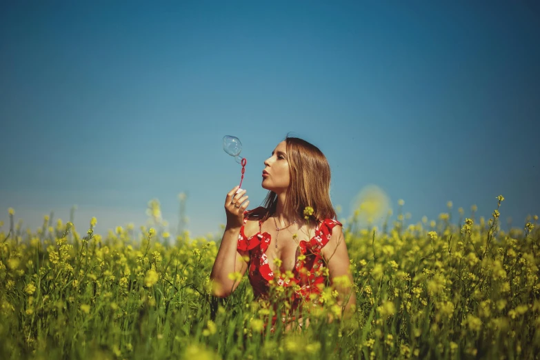 a young woman is standing in a field with a erfly wand