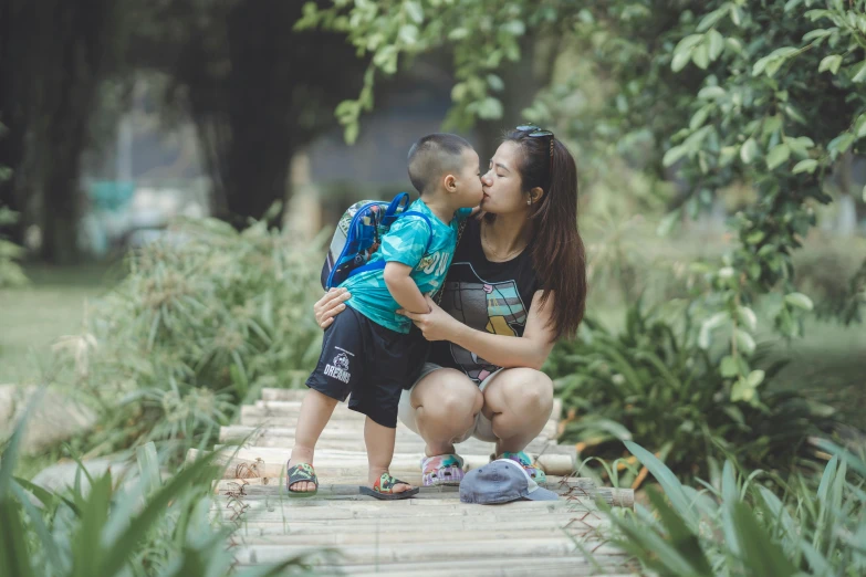 a woman holding onto a child kissing them