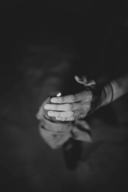 two hands reaching towards each other in a dark room