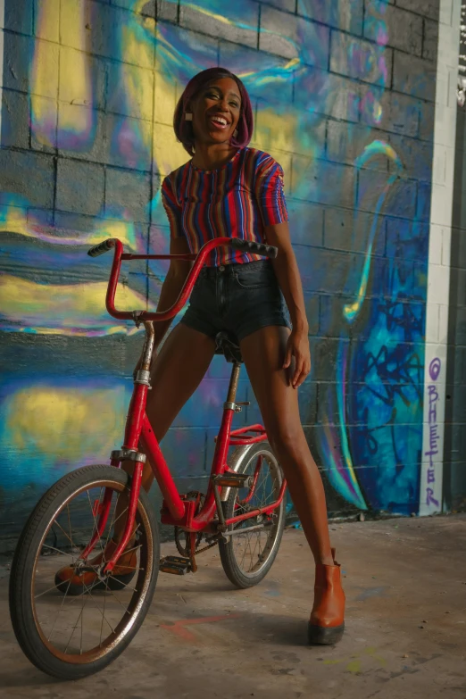 a beautiful woman wearing shorts and holding a red bike