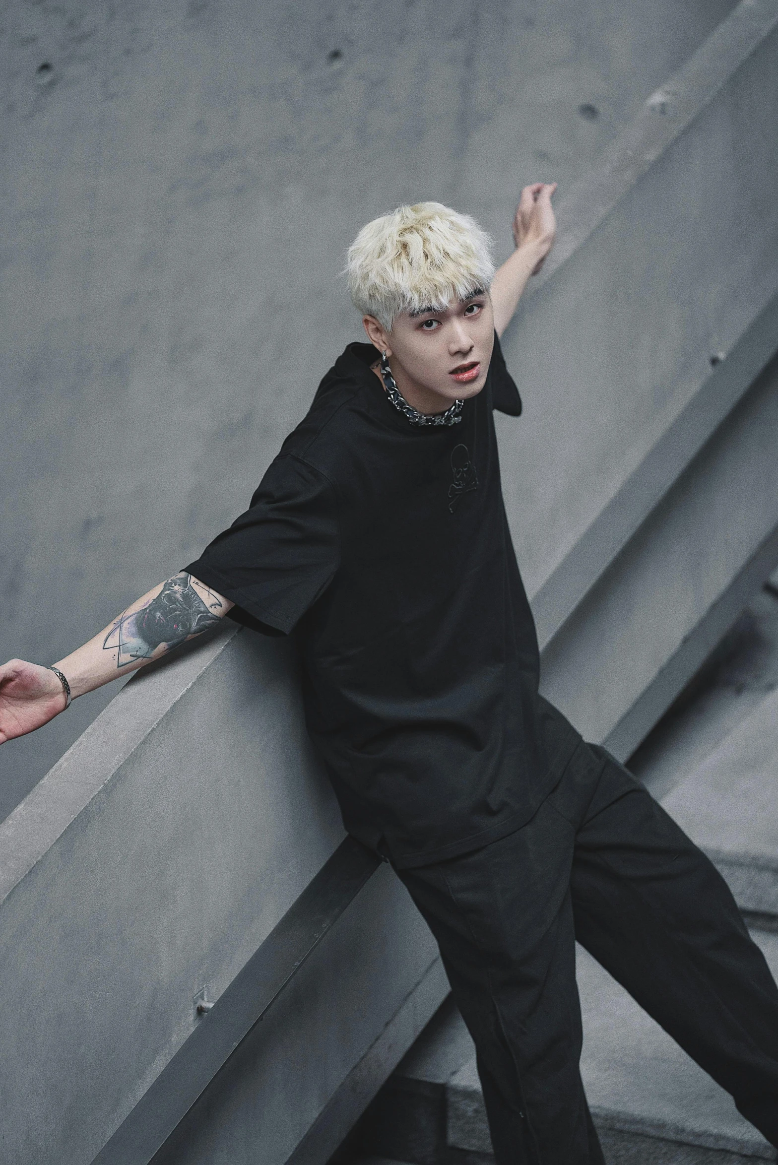 a man standing on stairs wearing a white mohawk