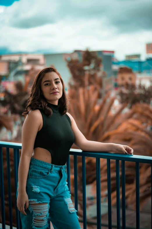 a beautiful young lady leaning against a rail