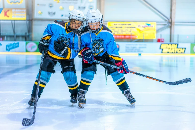 two men playing ice hockey on an indoor rink