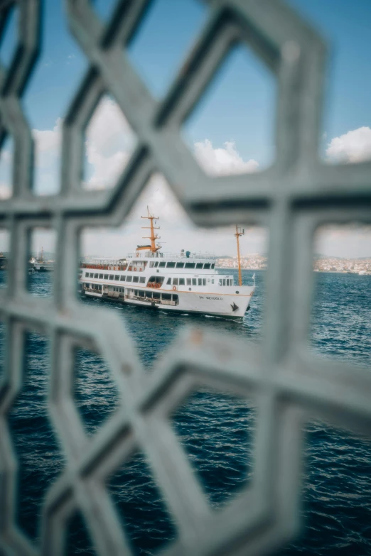 a boat is on the water through the fence