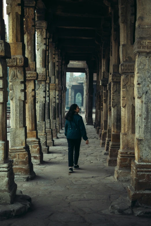 a woman standing inside of a covered walkway