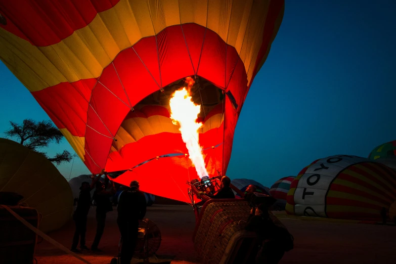 a balloon glows brightly in the sky as people watch