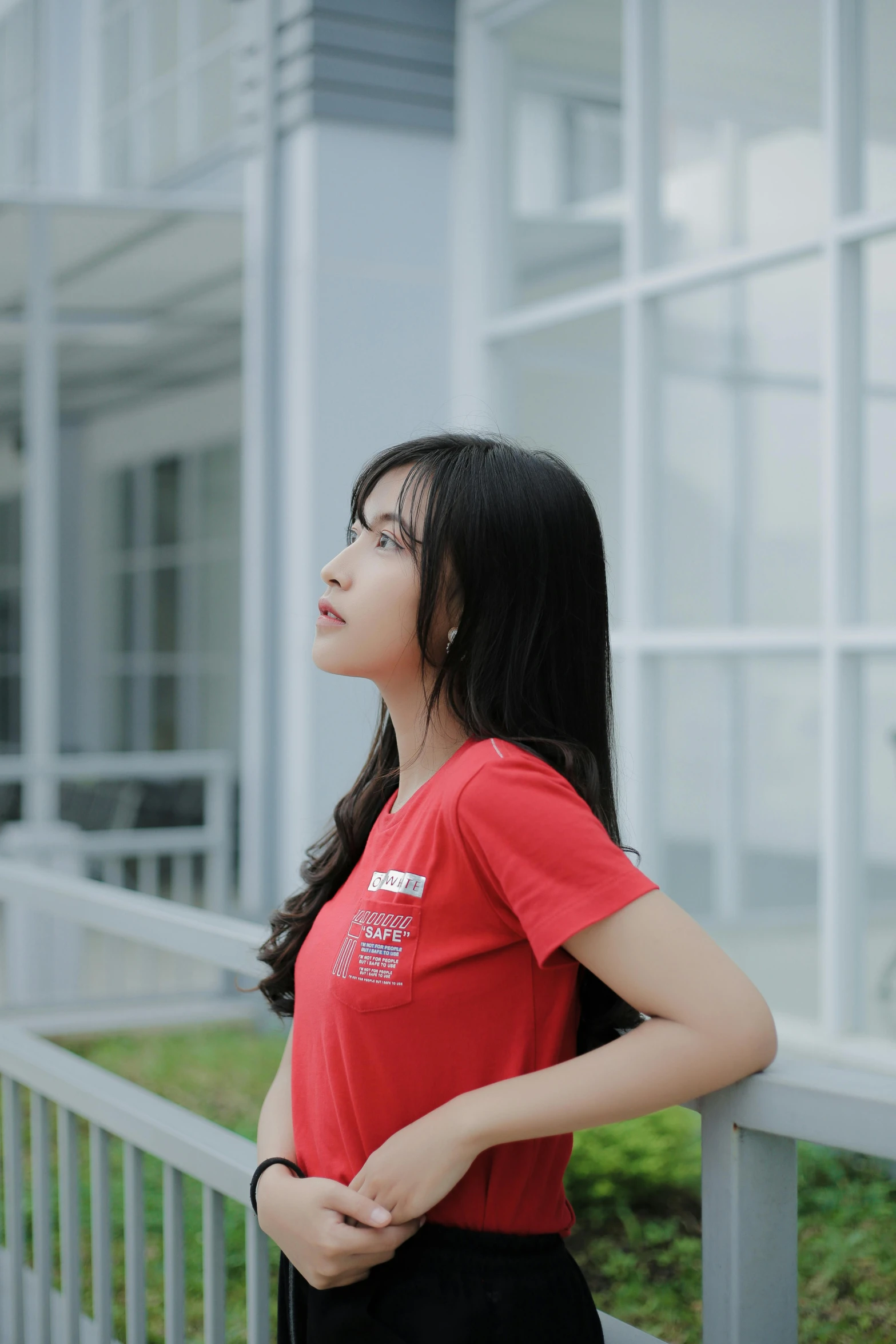 a beautiful young lady standing near a railing