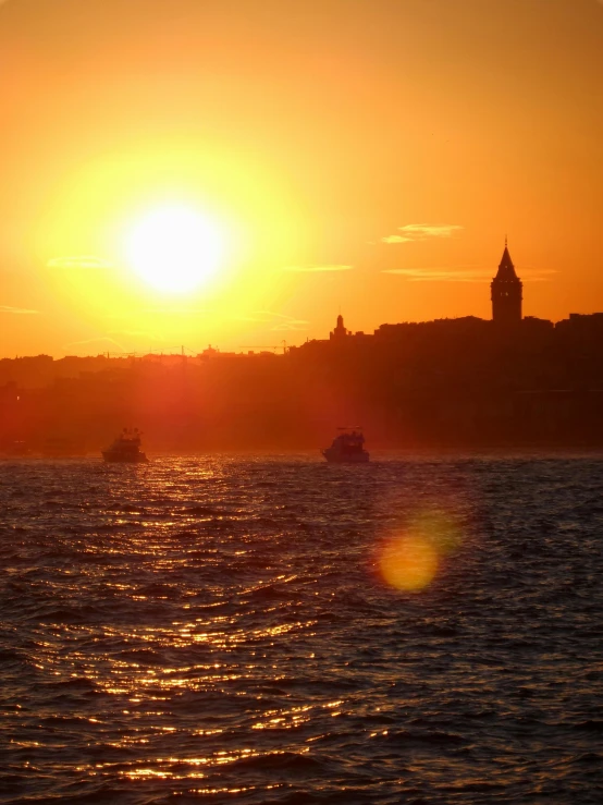 a boat sits on the water in front of a sunset