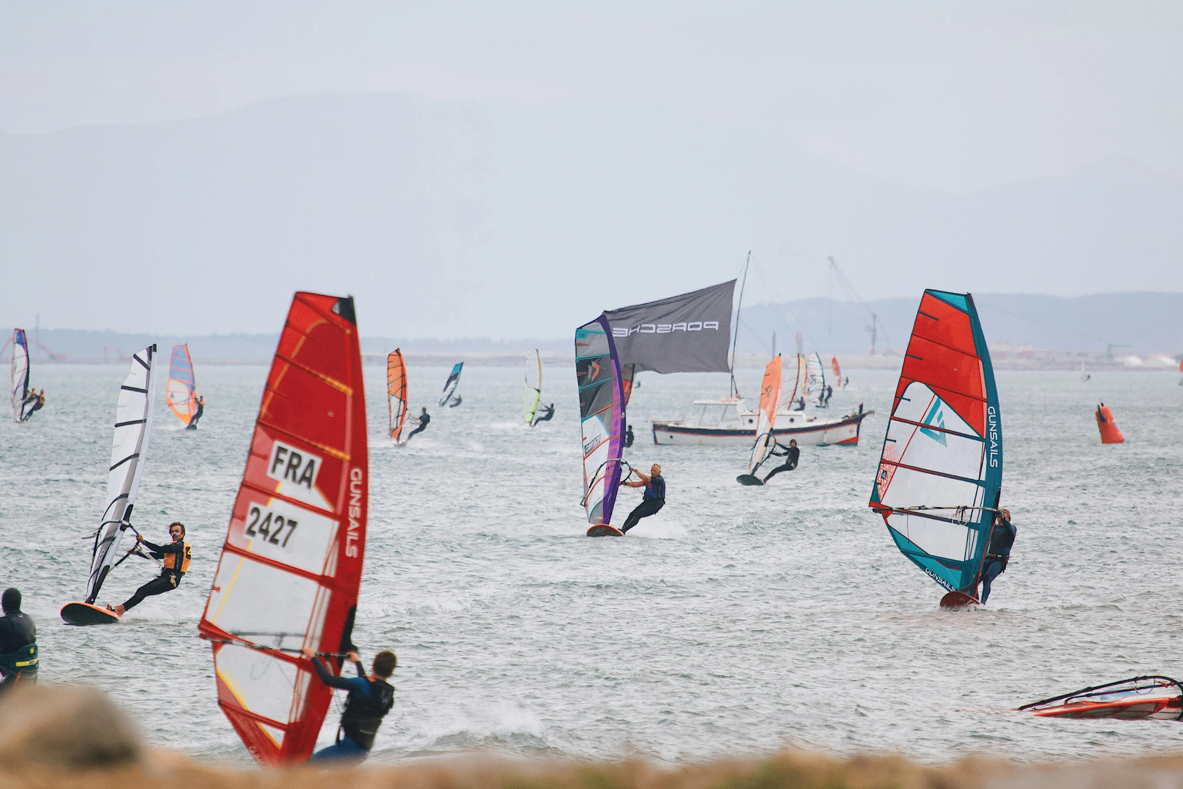 a large group of windsurfers in a large open ocean